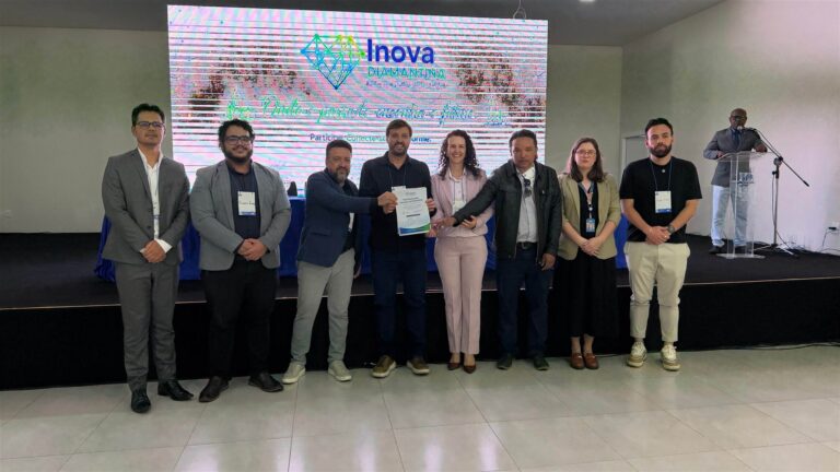 Participantes do encontro apresentam um documento diante do palco do Pacto pela Inovação de Diamantina.