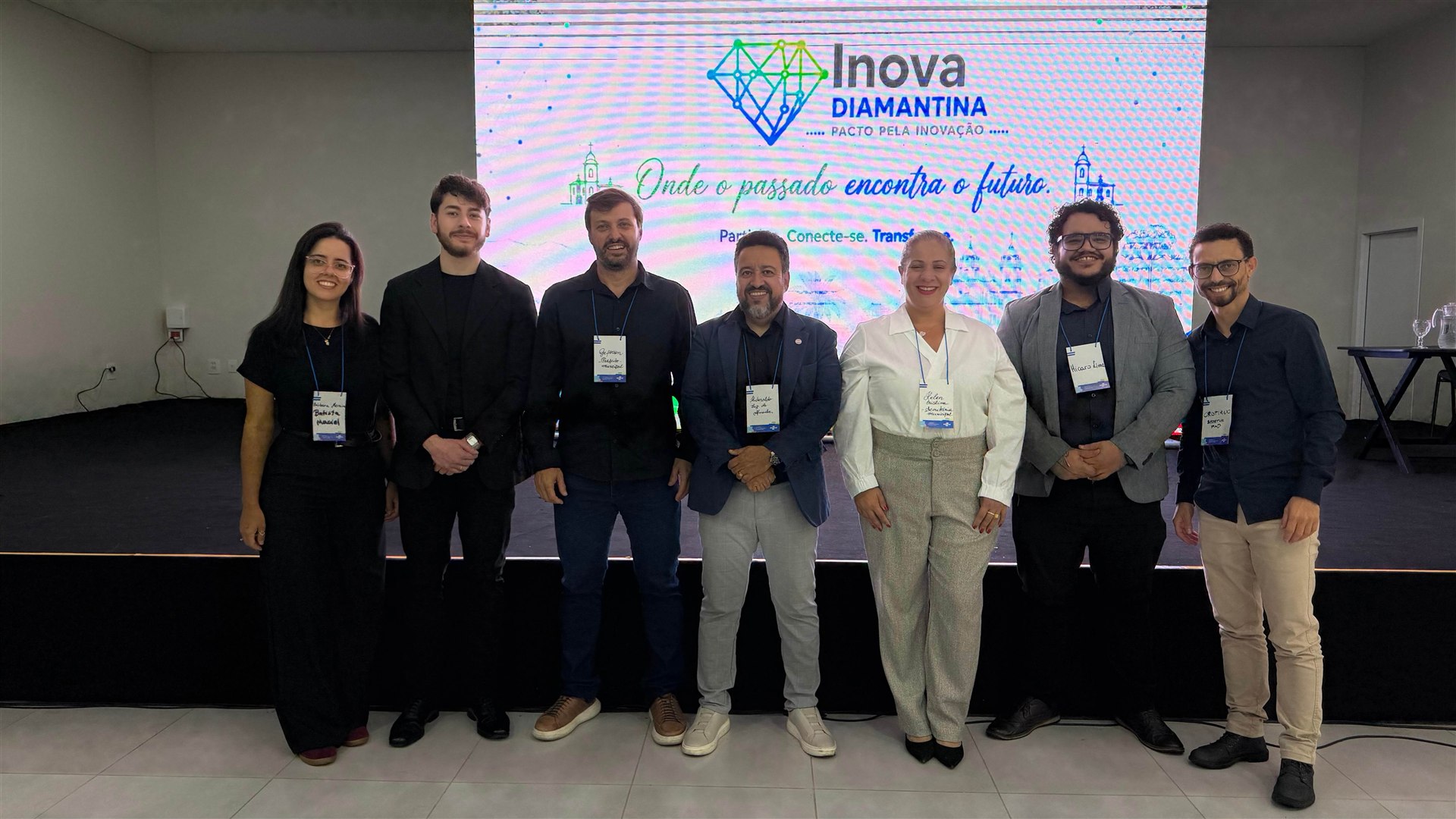 Grupo de participantes reunido diante do palco do Pacto pela Inovação de Diamantina.